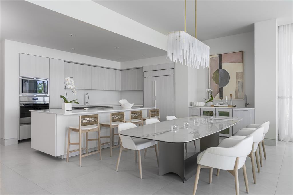 A modern kitchen and dining area with light wood cabinetry, a marble-topped table, and stools — Ocean Drive FOUR SEASONS PRIVATE RESIDENCES UNIT 6401, RIO GRANDE, PR