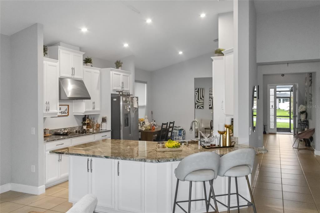 A kitchen with white cabinets, granite countertops, a center island, and bar seating — 3958 CARRICK BEND DRIVE, KISSIMMEE, FL
