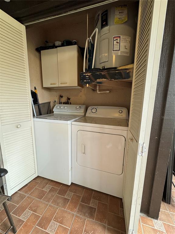 A laundry closet contains a washer, dryer, wall cabinets, and a water heater — 3545 59TH AVENUE W UNIT 3545, BRADENTON, FL