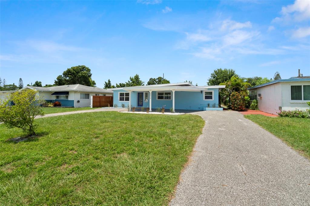 A light blue single-story house with a front carport and a paved driveway — 5813 18TH AVENUE S, GULFPORT, FL