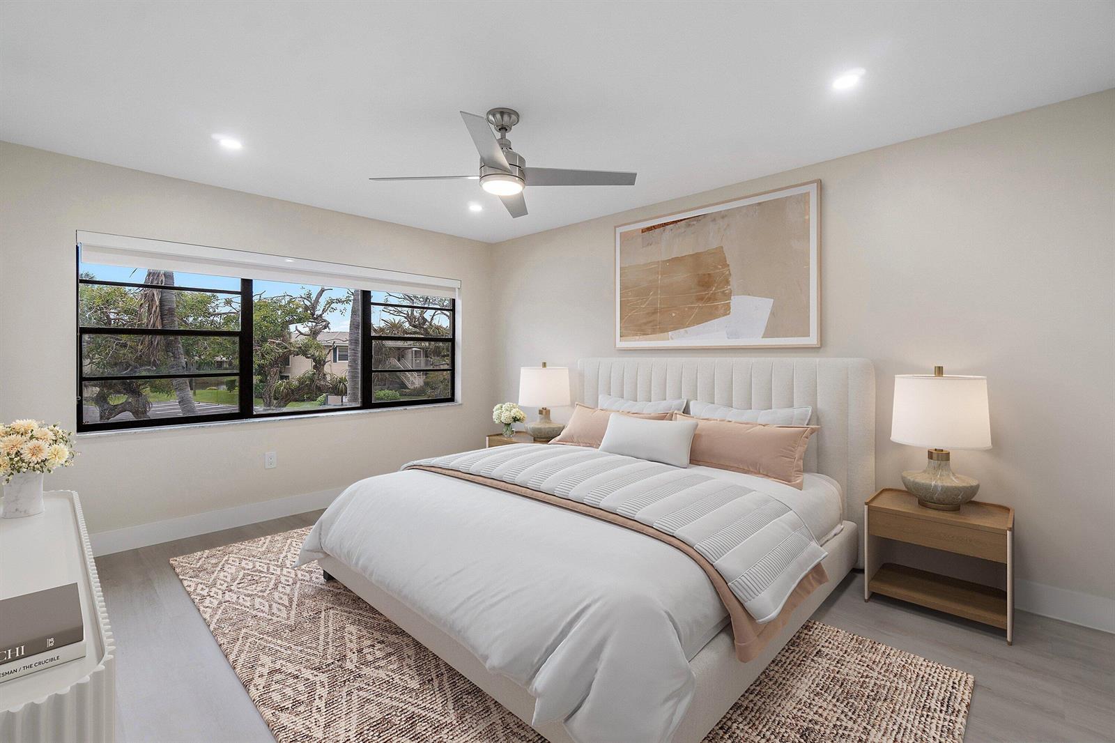A modern bathroom features a white vanity with a lighted mirror and a toilet — 16 Stratford Drive E # C, Boynton Beach FL 33436, BOYNTON BEACH, FL