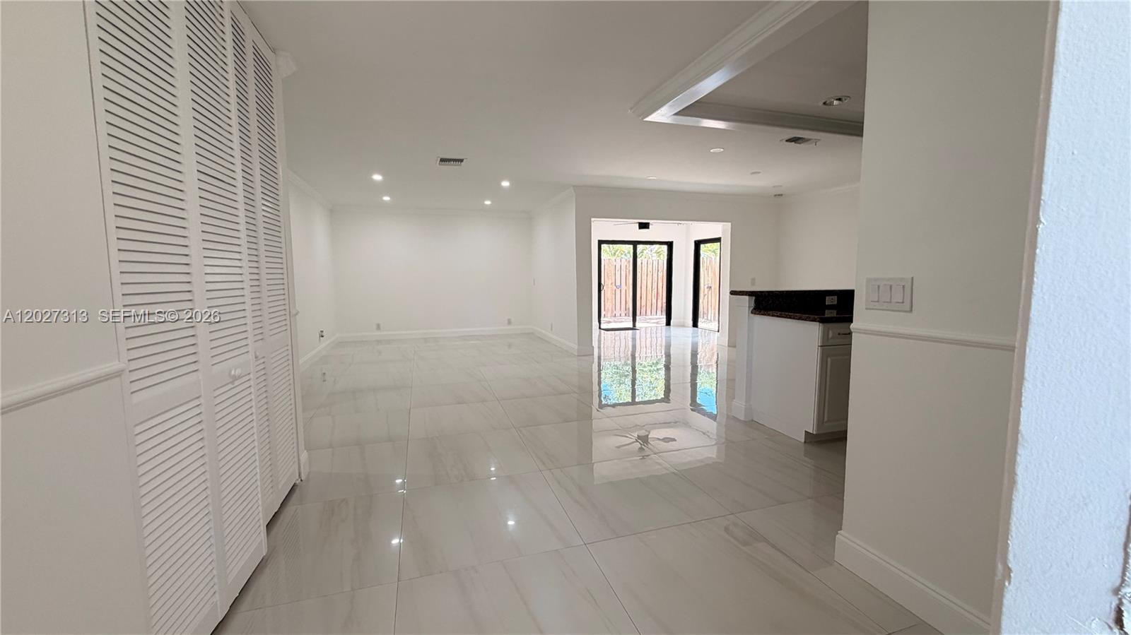 A bright, open-concept living area features white tile flooring, recessed lighting, and a kitchen counter — 36 Chestnut Cir, # 36, Cooper City FL 33026, COOPER CITY, FL