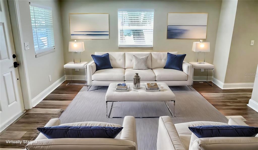 A living room features a white sofa, two armchairs, a tufted ottoman, and blue accents — 1707 E NEW ORLEANS AVENUE, TAMPA, FL