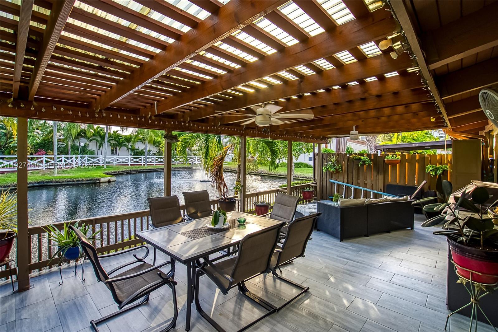 A covered outdoor patio features a dining set, lounge furniture, and views of a canal — 2669 S Parkview Dr, Hallandale Beach FL 33009, HALLANDALE BEACH, FL