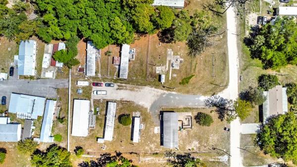 This aerial view shows a residential property with multiple mobile homes and a dirt road — 8333 EMMONS AVENUE, NEW PORT RICHEY, FL