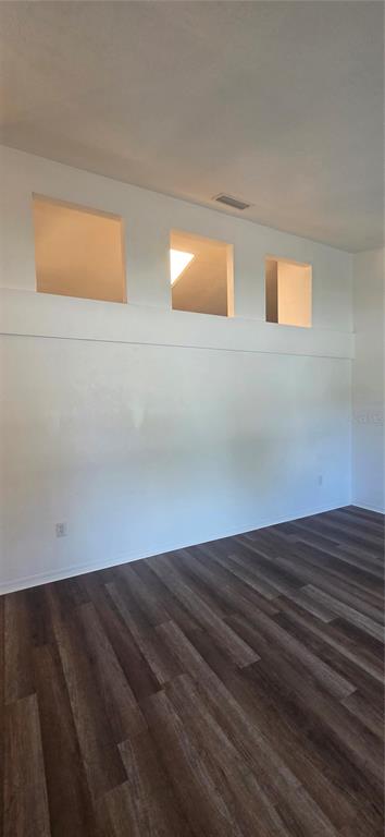 A room with wood-look flooring and three square cutouts in the upper wall — 1419 NW 89TH TERRACE, GAINESVILLE, FL