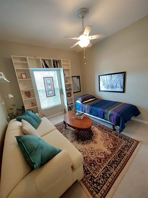 A bedroom features a daybed, a sofa, a wooden coffee table, and built-in shelving — 2633 NE 27TH STREET, OCALA, FL