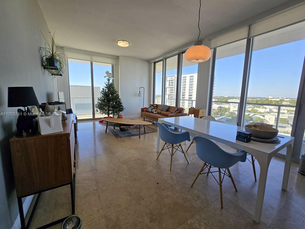 A bright living and dining area features tile floors, floor-to-ceiling windows, and a city view — 3470 E Coast Ave # H1404, Miami FL 33137, MIAMI, FL