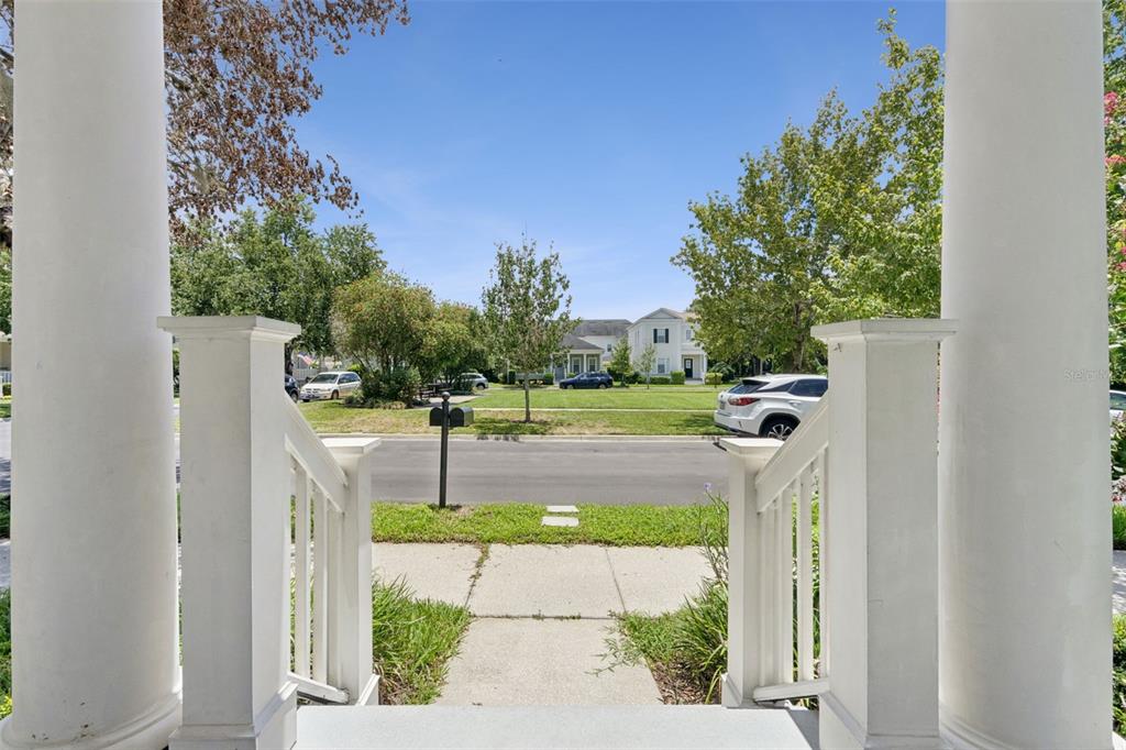 A view from a front porch looking out toward a street and neighborhood houses — 1102 GOLDENASTER COURT, CELEBRATION, FL