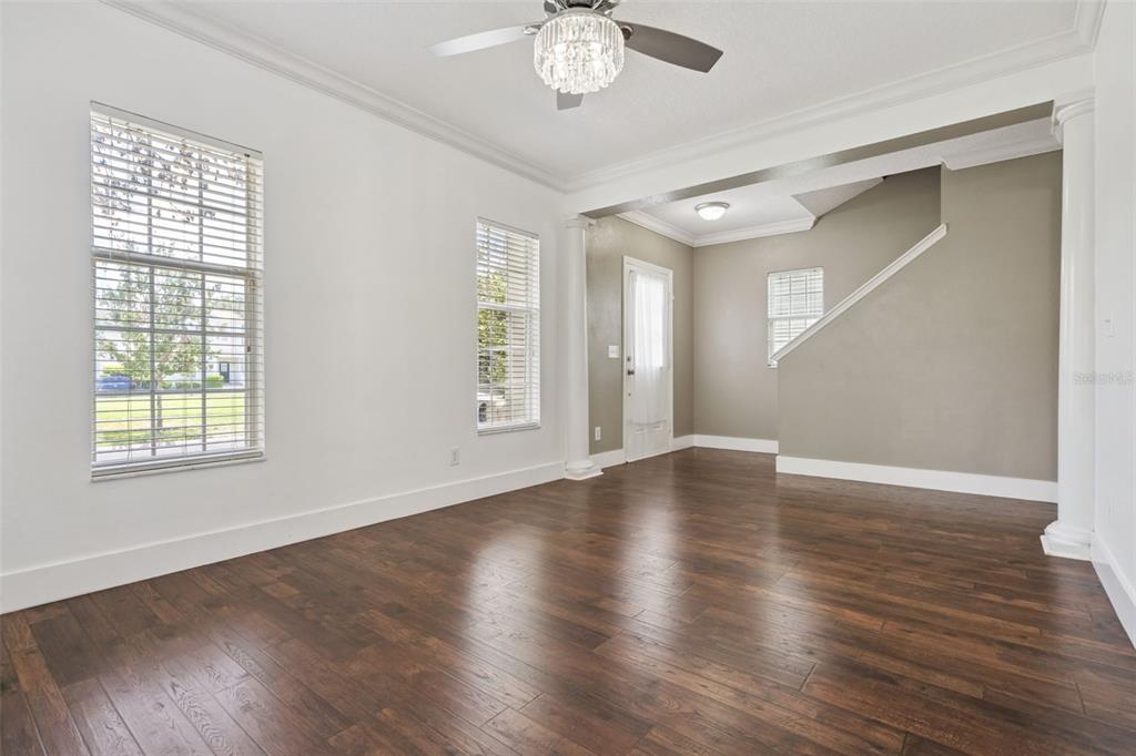 An empty room with dark wood flooring, white walls, two windows, and a ceiling fan — 1102 GOLDENASTER COURT, CELEBRATION, FL