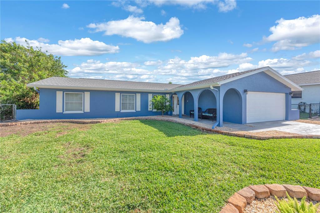 A blue single-story house with a white garage door and a covered front porch — 911 SILVER PALM WAY, APOLLO BEACH, FL