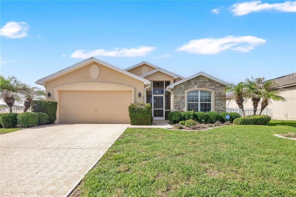 A single-story suburban house with a tan stucco exterior, stone accents, and a two-car garage — 4919 ST JAMES DRIVE, WINTER HAVEN, FL