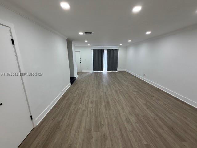 An empty room features light wood-look flooring, white walls, recessed lighting, and dark window curtains — 13725 SW 84th St # C, Miami FL 33183, MIAMI, FL