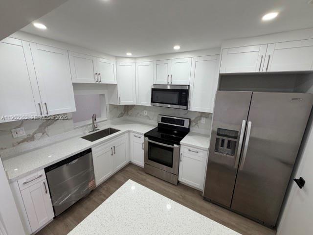 A modern kitchen features white cabinetry, stainless steel appliances, and light-colored quartz countertops — 13725 SW 84th St # C, Miami FL 33183, MIAMI, FL