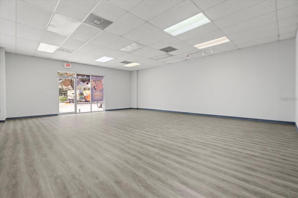 An empty commercial space features light gray wood-look flooring, white walls, and a drop ceiling — 1650 TROPIC PARK DRIVE UNIT 1650, SANFORD, FL