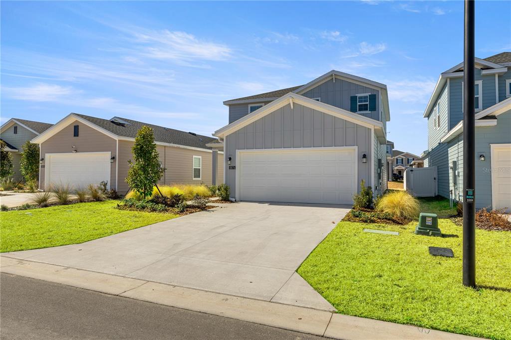 A two-story light blue house with a two-car garage and a concrete driveway — 8708 SW 67TH TERRACE, OCALA, FL