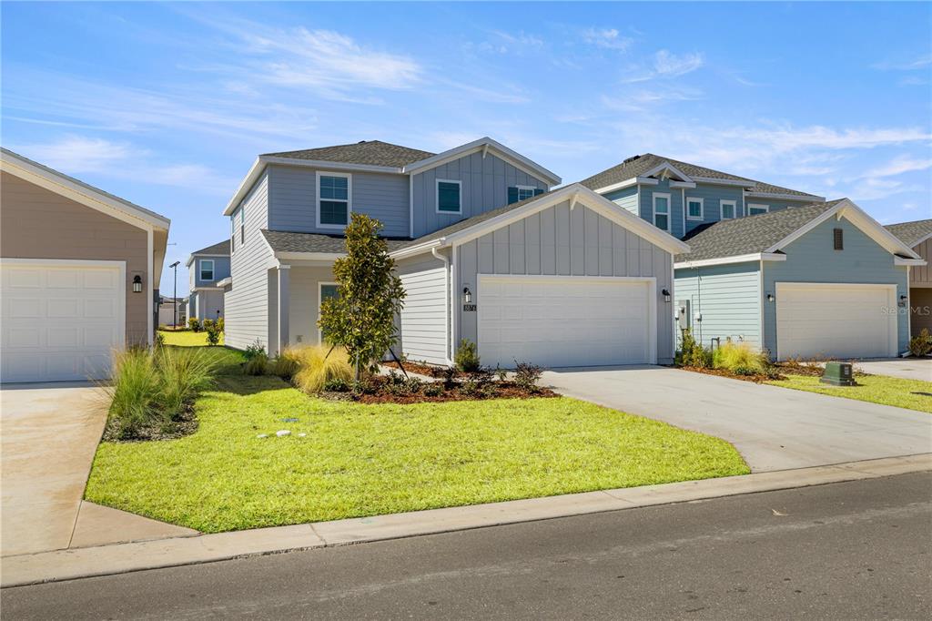 A two-story light gray house with a two-car garage and a front lawn — 8708 SW 67TH TERRACE, OCALA, FL
