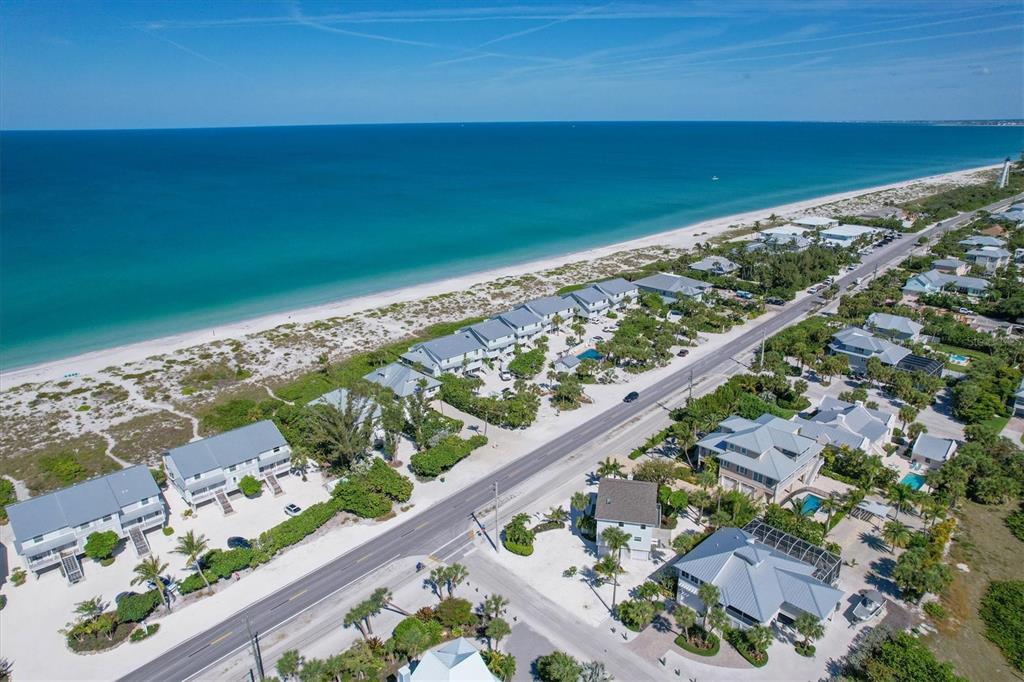 An aerial view shows beach houses along a coastal road next to the ocean — 401 LAFITTE STREET, BOCA GRANDE, FL