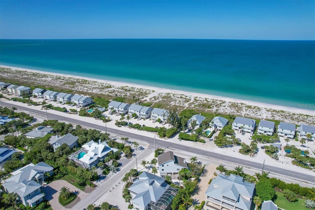 An aerial view of a coastal neighborhood with houses situated along a beach and ocean — 401 LAFITTE STREET, BOCA GRANDE, FL