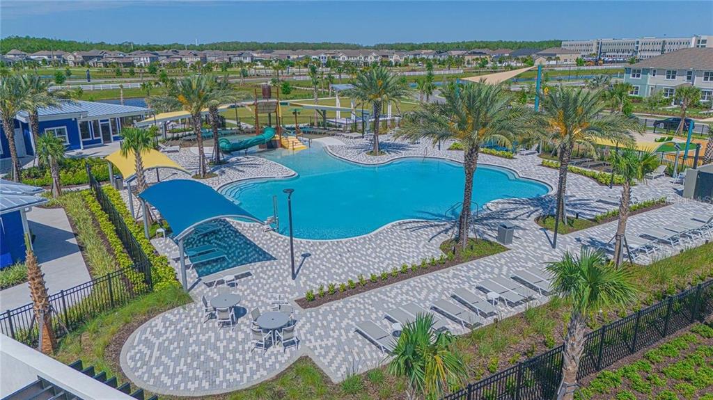 An aerial view of a community swimming pool with a water slide and lounge chairs — 11420 SUNSAIL AVENUE, ORLANDO, FL
