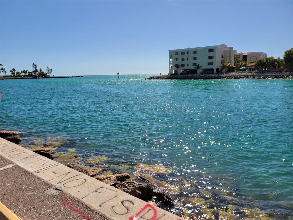 A view of a waterway with a large multi-story building on the opposite shore — 7650 COQUINA WAY UNIT 3, ST PETE BEACH, FL