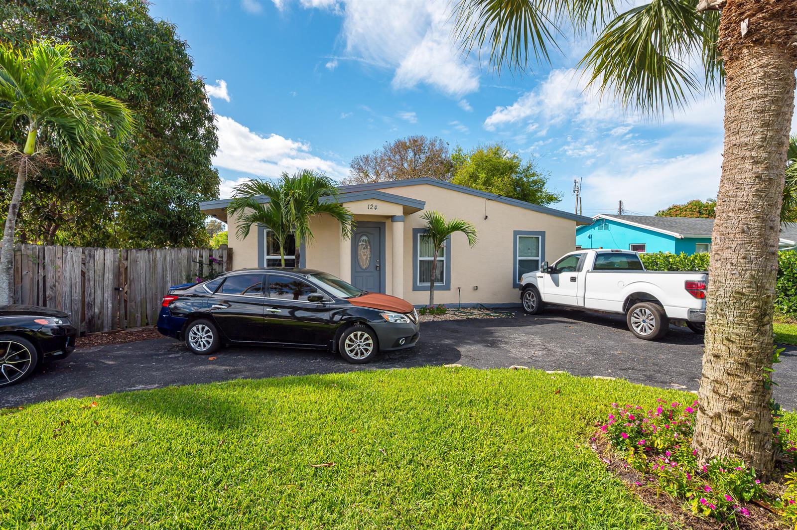 A one-story house with a beige exterior, a front porch, and two cars parked in the driveway — 124 SW 10th Avenue, Boynton Beach FL 33435, BOYNTON BEACH, FL