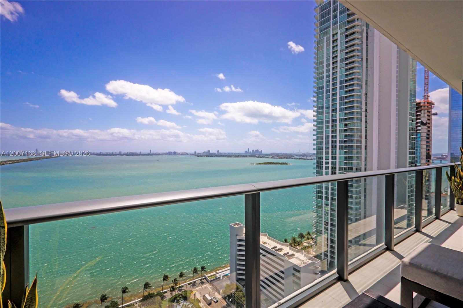A high-rise balcony overlooks a large bay with a city skyline in the distance — 480 NE 31st St # 2405, Miami FL 33137, MIAMI, FL