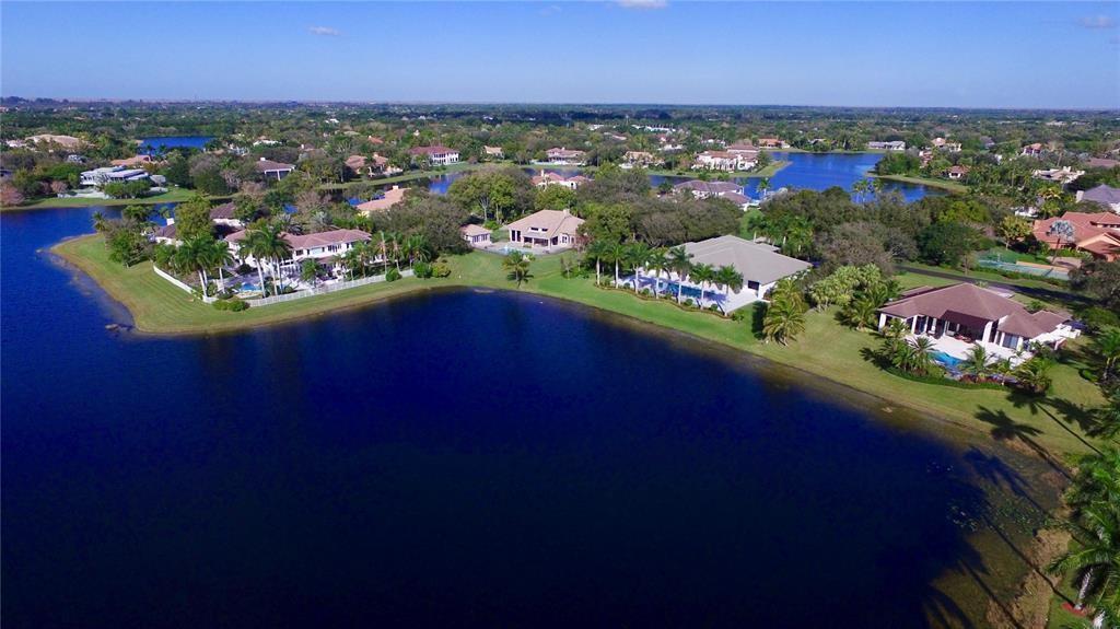 An aerial view of several waterfront houses with swimming pools surrounded by lush green landscaping — 3190 Willow Lane, Weston FL 33331, WESTON, FL