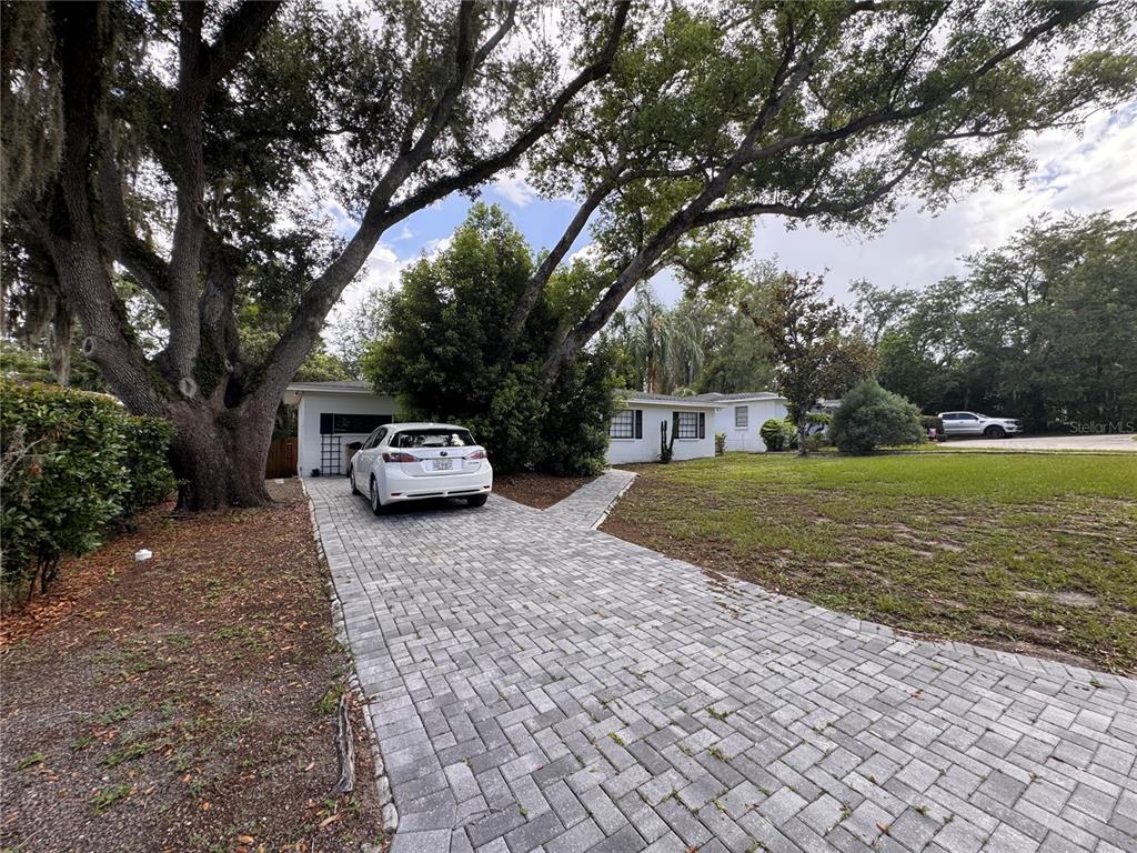 A white car is parked on a paved driveway in front of a single-story house — 309 DEER PARK AVENUE, TAMPA, FL
