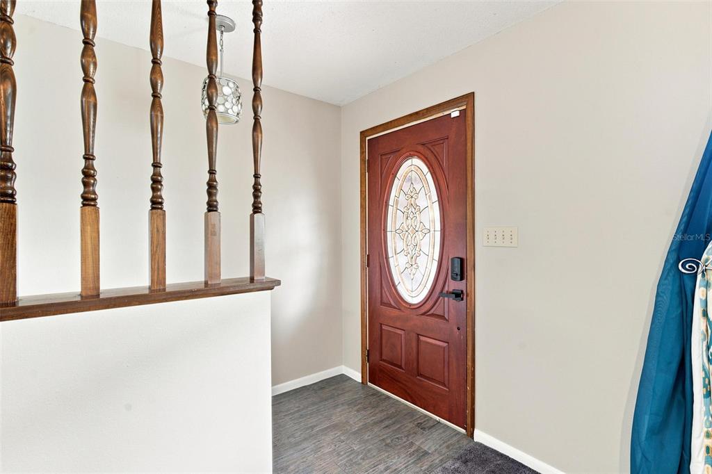 An entryway features a wooden staircase railing, a front door with a decorative glass insert — 5118 MAGNOLIA TERRACE, FRUITLAND PARK, FL