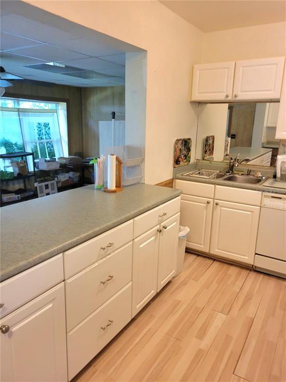 A kitchen features white cabinets, a green countertop, and light wood-look flooring — 5400 SAN JUAN BOULEVARD, ORLANDO, FL