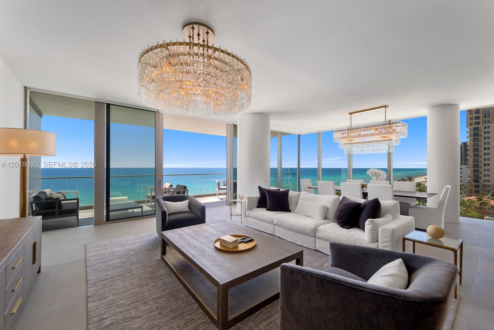 A modern living and dining room features floor-to-ceiling windows with expansive ocean views — 2000 S Ocean Dr # 7B, Hallandale Beach FL 33009, HALLANDALE BEACH, FL