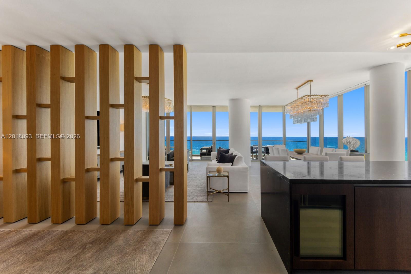A modern living and dining area features a wooden slat room divider and ocean views — 2000 S Ocean Dr # 7B, Hallandale Beach FL 33009, HALLANDALE BEACH, FL