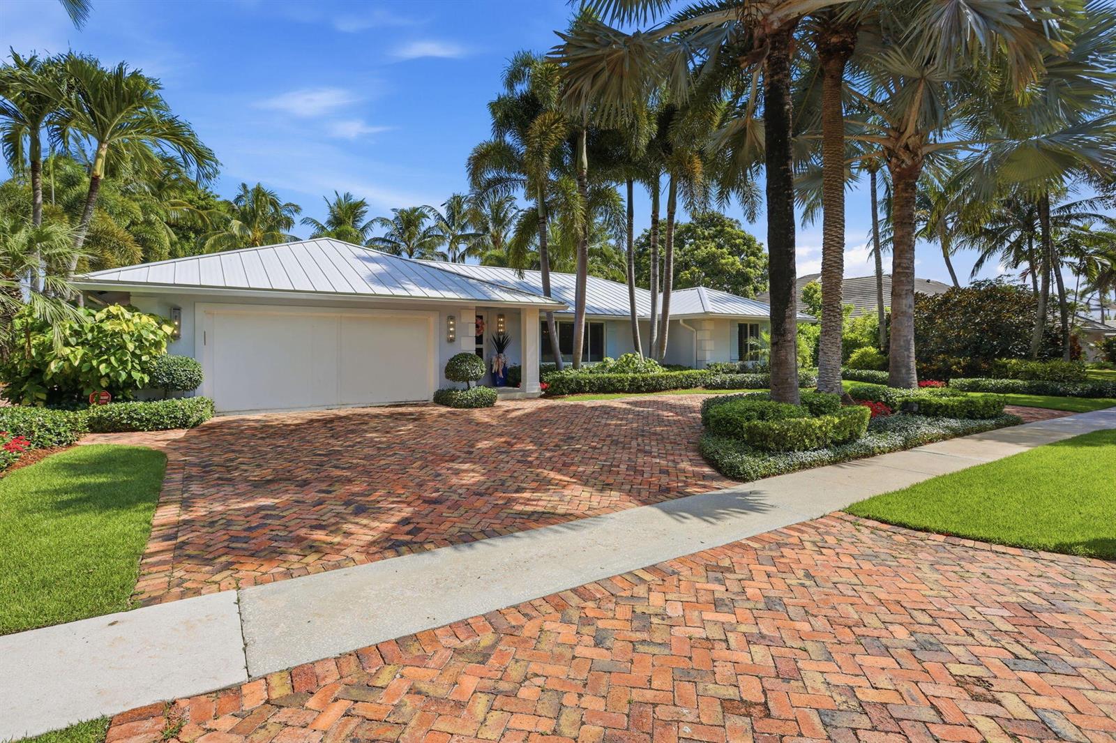 A single-story house with a metal roof and a brick driveway surrounded by palm trees — 2151 NW 30th Road, Boca Raton FL 33431, BOCA RATON, FL