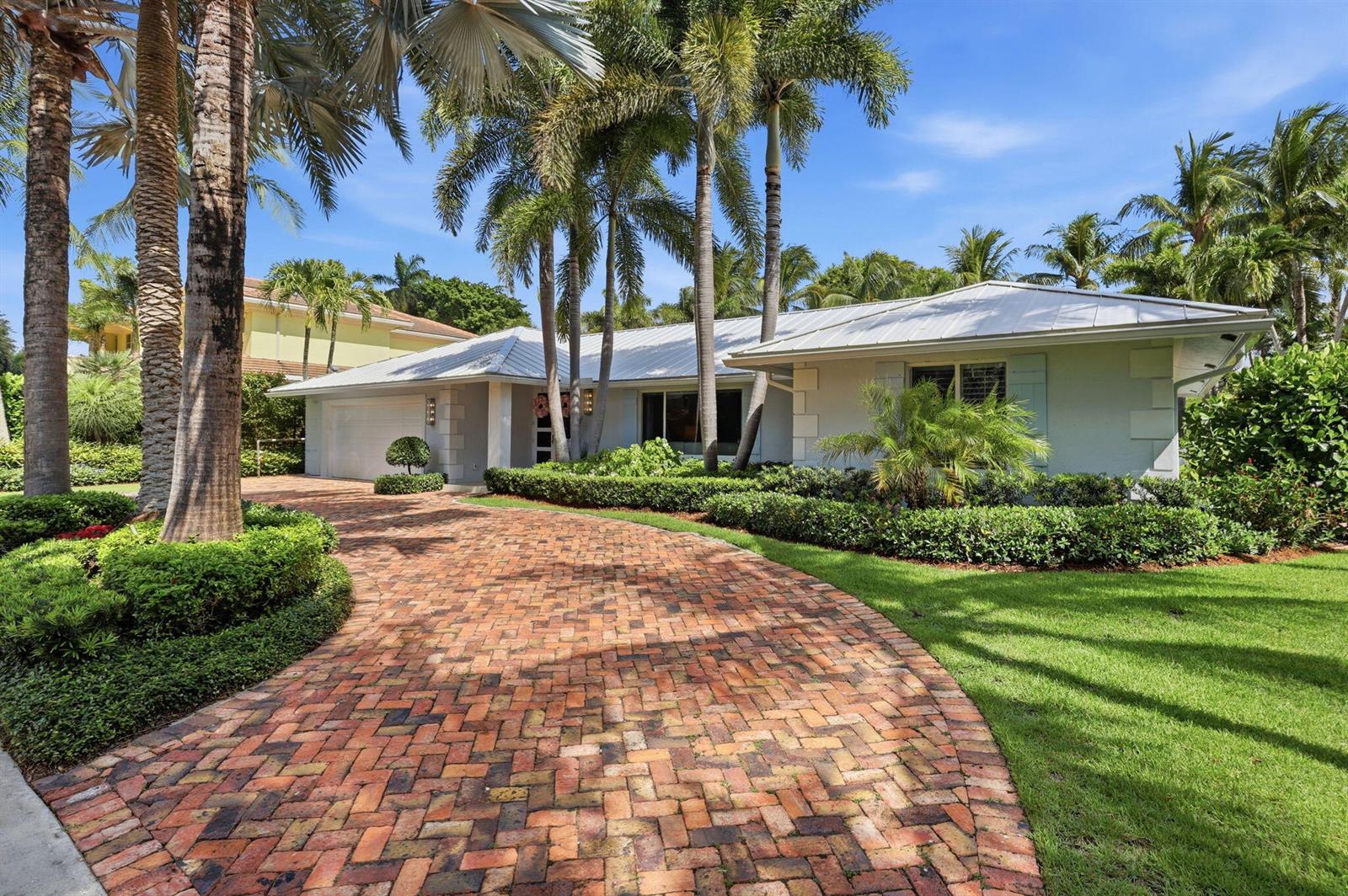 A single-story house with a brick driveway, metal roof, and palm trees in the yard — 2151 NW 30th Road, Boca Raton FL 33431, BOCA RATON, FL
