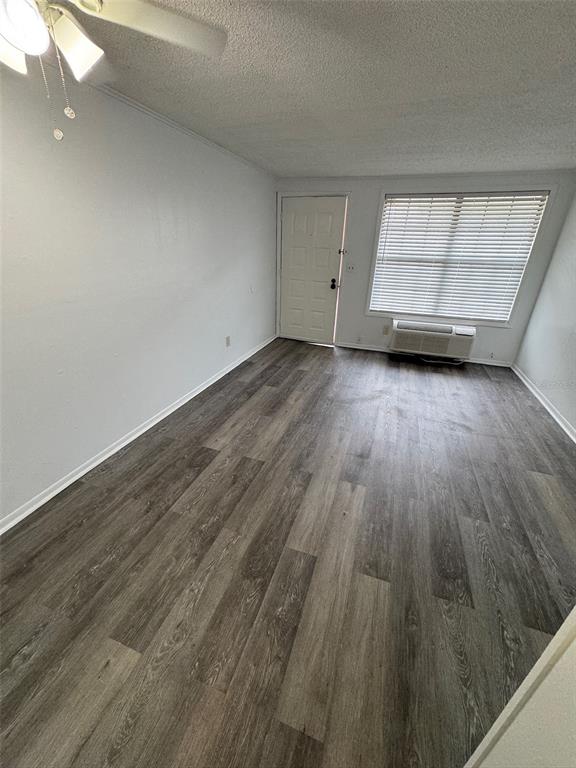 An empty room features gray wood-look flooring, white walls, a ceiling fan, and a window — 420-420 MILLS STREET UNIT 25, LEESBURG, FL