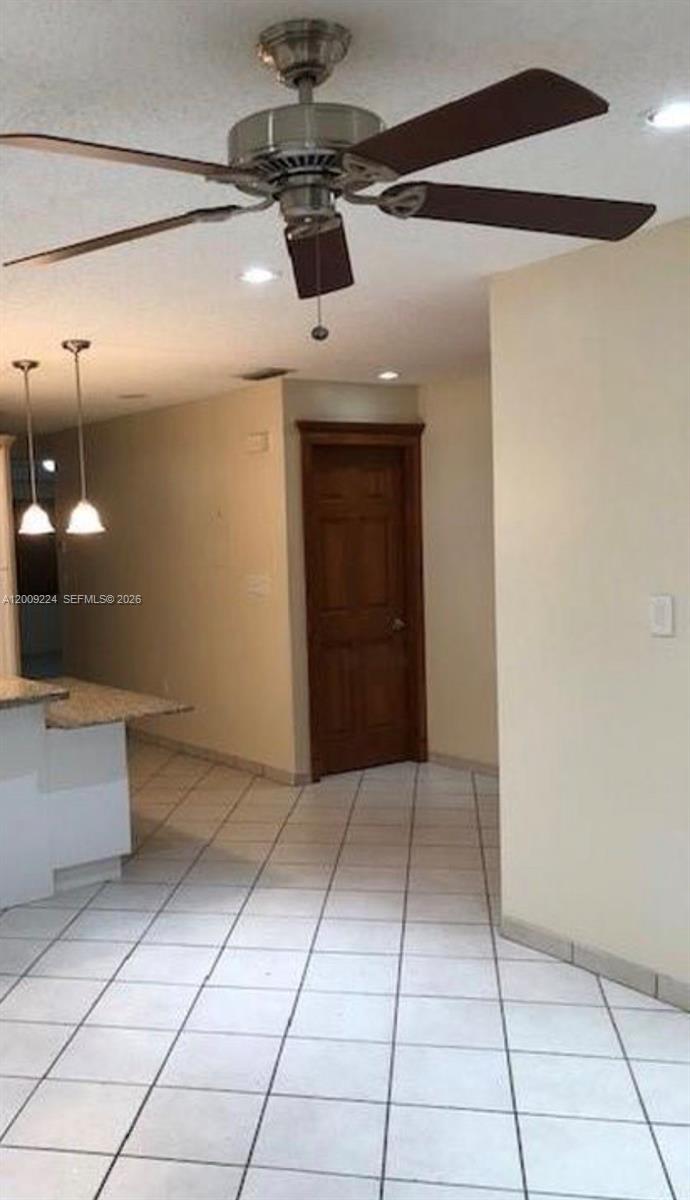 A room with tiled flooring, a ceiling fan, and a wooden door — HIALEAH GARDENS, FL