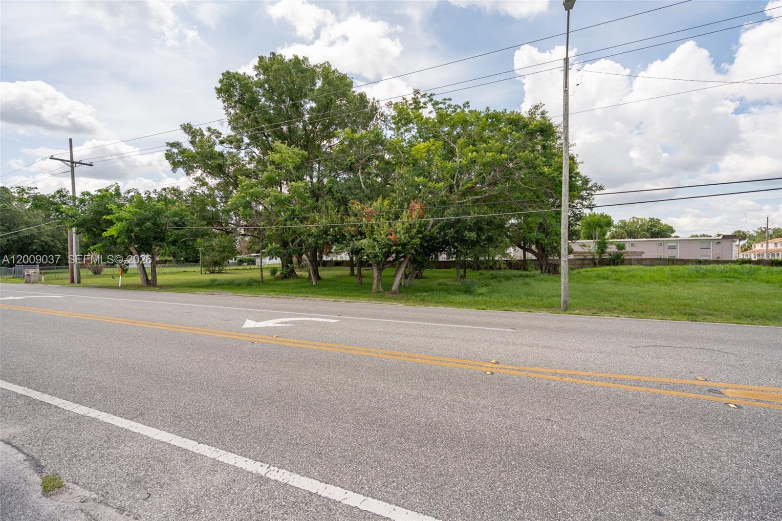 A vacant, tree-filled lot is outlined in yellow next to a paved road — 5574 Old Cheney Highway, Orlando FL 32807, ORLANDO, FL