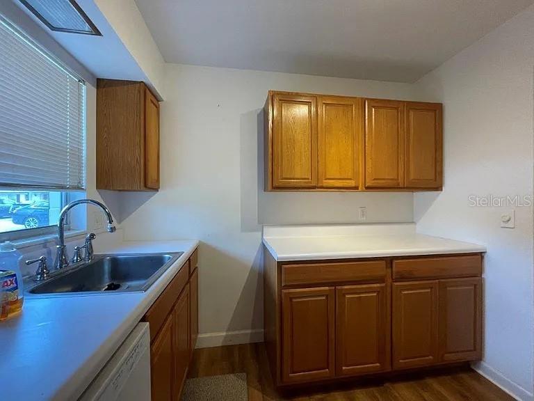A kitchen features wood cabinets, white countertops, a stainless steel sink, and a window — 120B E MINNESOTA AVENUE UNIT B, DELAND, FL