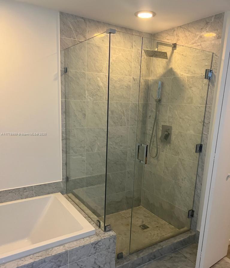 A bathroom features a glass-enclosed shower with marble tile walls and a soaking tub — 801 S Miami Ave # 5108, Miami FL 33130, MIAMI, FL