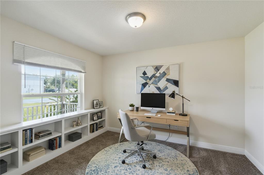 A home office features a built-in bookshelf, a wooden desk, and a window with blinds — 545 VICEROY COURT, KISSIMMEE, FL