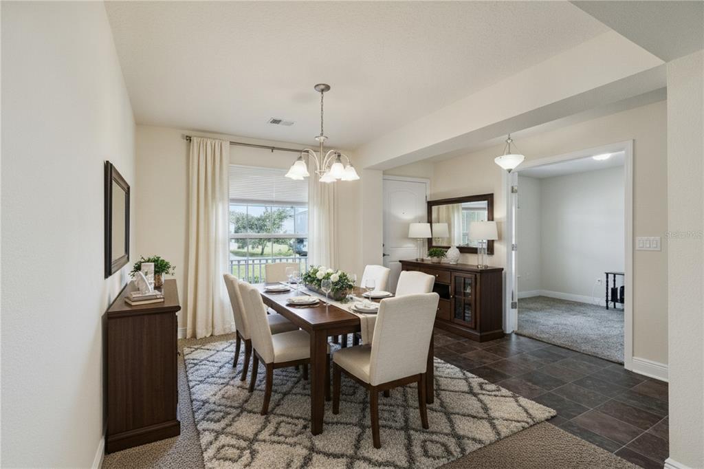 A dining room features a wooden table, six upholstered chairs, a rug, and two sideboards — 545 VICEROY COURT, KISSIMMEE, FL