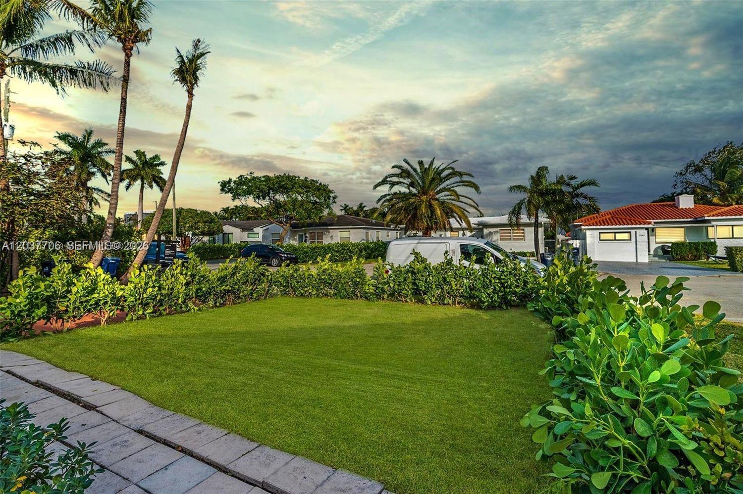 A grassy front yard with palm trees and a white van parked on the street — 9156 Froude Ave, Surfside FL 33154, SURFSIDE, FL