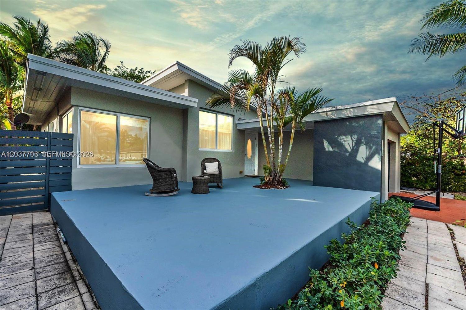 A gray house features a large blue patio, a palm tree, and a basketball hoop — 9156 Froude Ave, Surfside FL 33154, SURFSIDE, FL