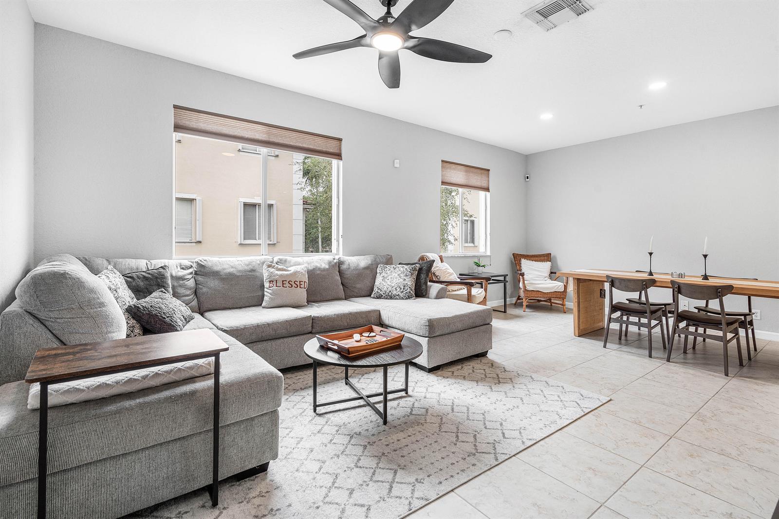 A living and dining area features a gray sectional sofa, a wooden table, and tile flooring — 2897 S Greenleaf Circle, Boynton Beach FL 33426, BOYNTON BEACH, FL