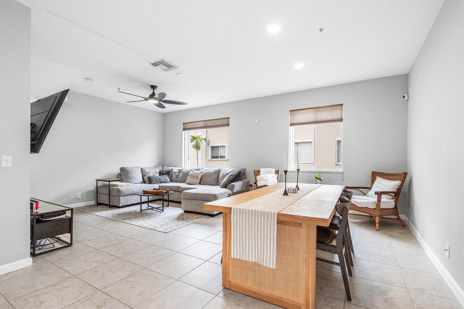 A living and dining area features a gray sectional sofa, wooden table, and tile flooring — 2897 S Greenleaf Circle, Boynton Beach FL 33426, BOYNTON BEACH, FL