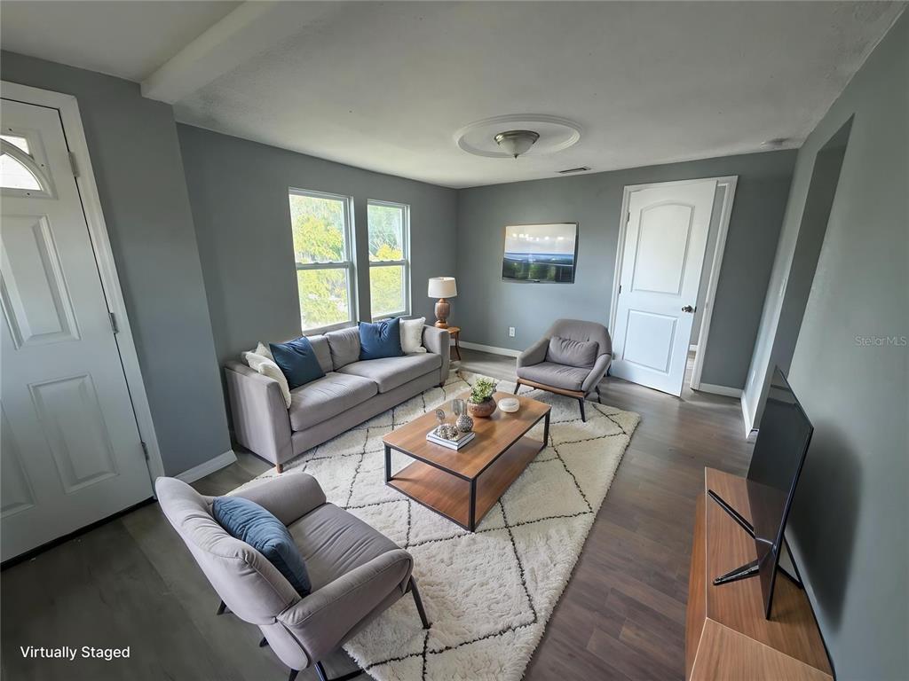 A living room with gray walls, wood floors, a white rug, and gray furniture — 1208 17TH ST N, ST PETERSBURG, FL