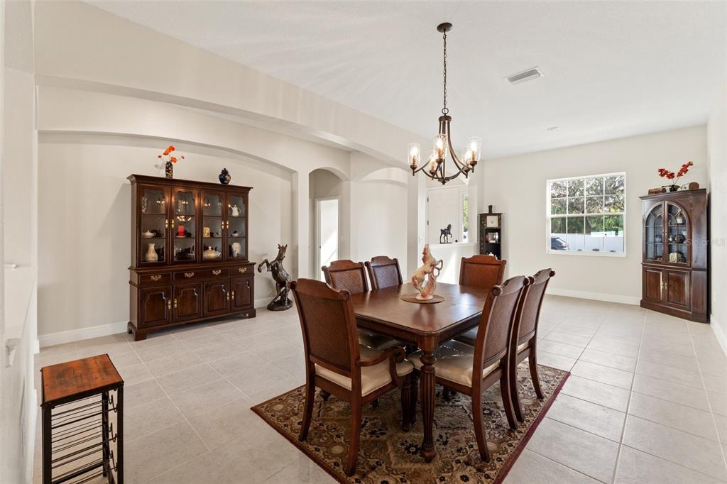 A dining room features a wooden table, chairs, two china cabinets, and a chandelier — 14421 NONNA SKY DRIVE DRIVE, SPRING HILL, FL