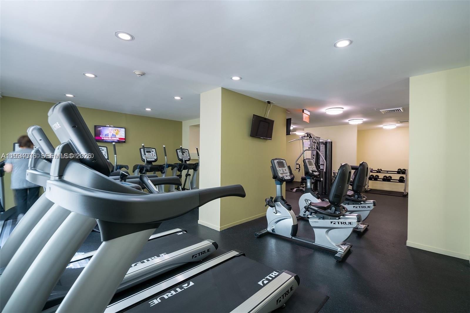 This gym features several treadmills, stationary bikes, a multi-station weight machine, and dumbbell racks — 9066 SW 73rd Ct # 1202, Miami FL 33156, MIAMI, FL