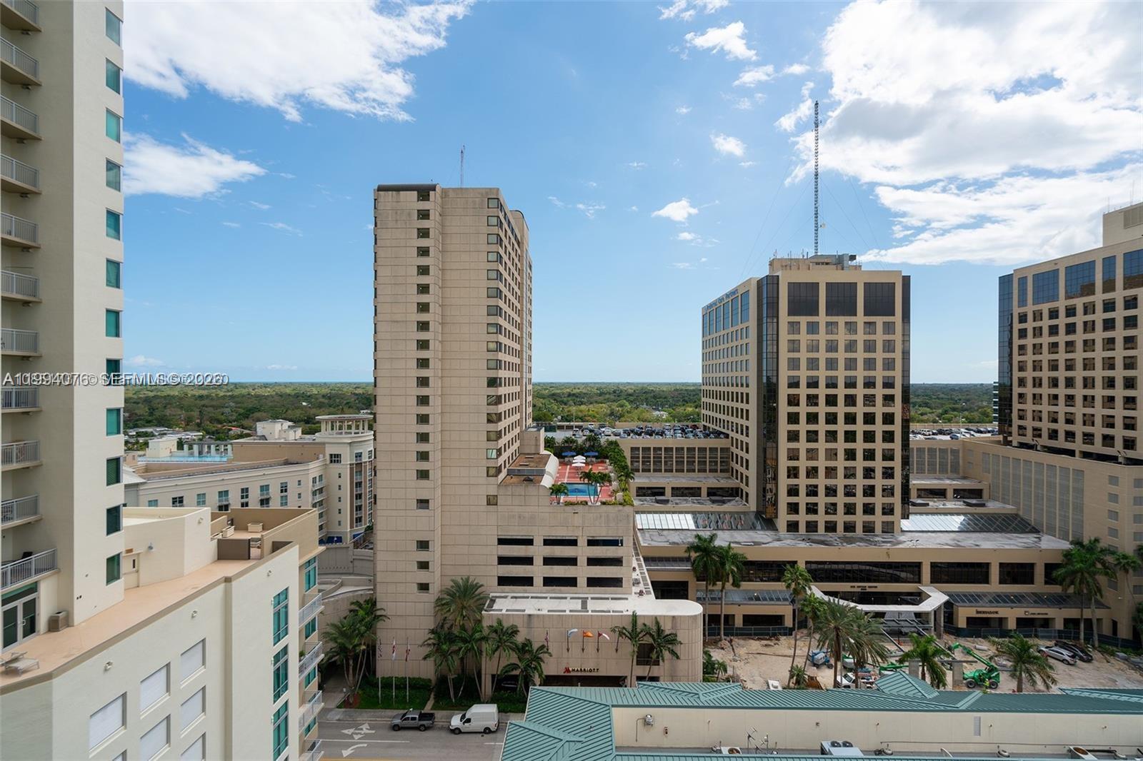 An elevated view shows several tall commercial and residential buildings with palm trees below — 9066 SW 73rd Ct # 1202, Miami FL 33156, MIAMI, FL